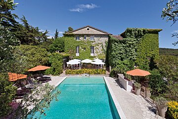 A large house with a swimming pool in front of it