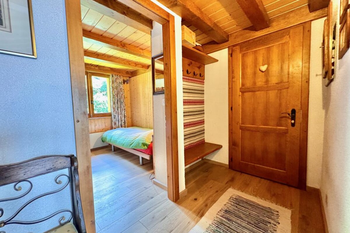 A bedroom with a small bed and a wooden door