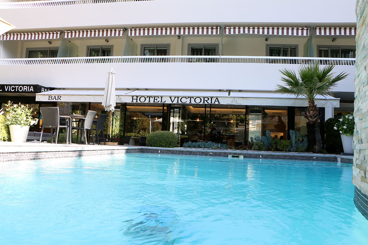 The hotel victoria has a swimming pool in front of it