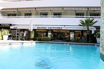 The hotel victoria has a swimming pool in front of it