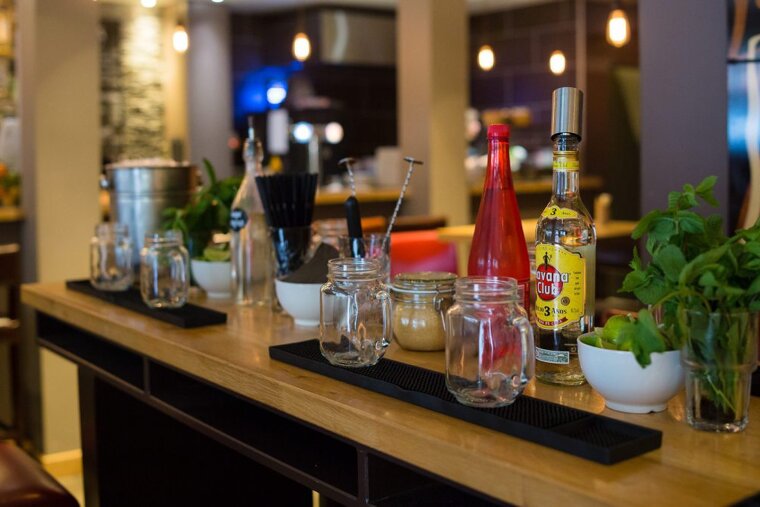 a bar with glass jars and spirits on the top