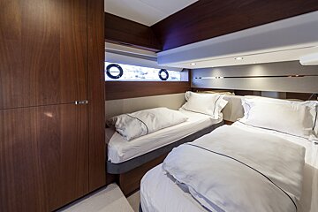 A small bedroom with two beds and a window