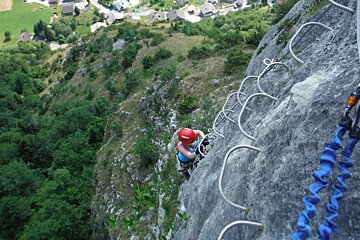 a woman climbing metal steps on a rock face