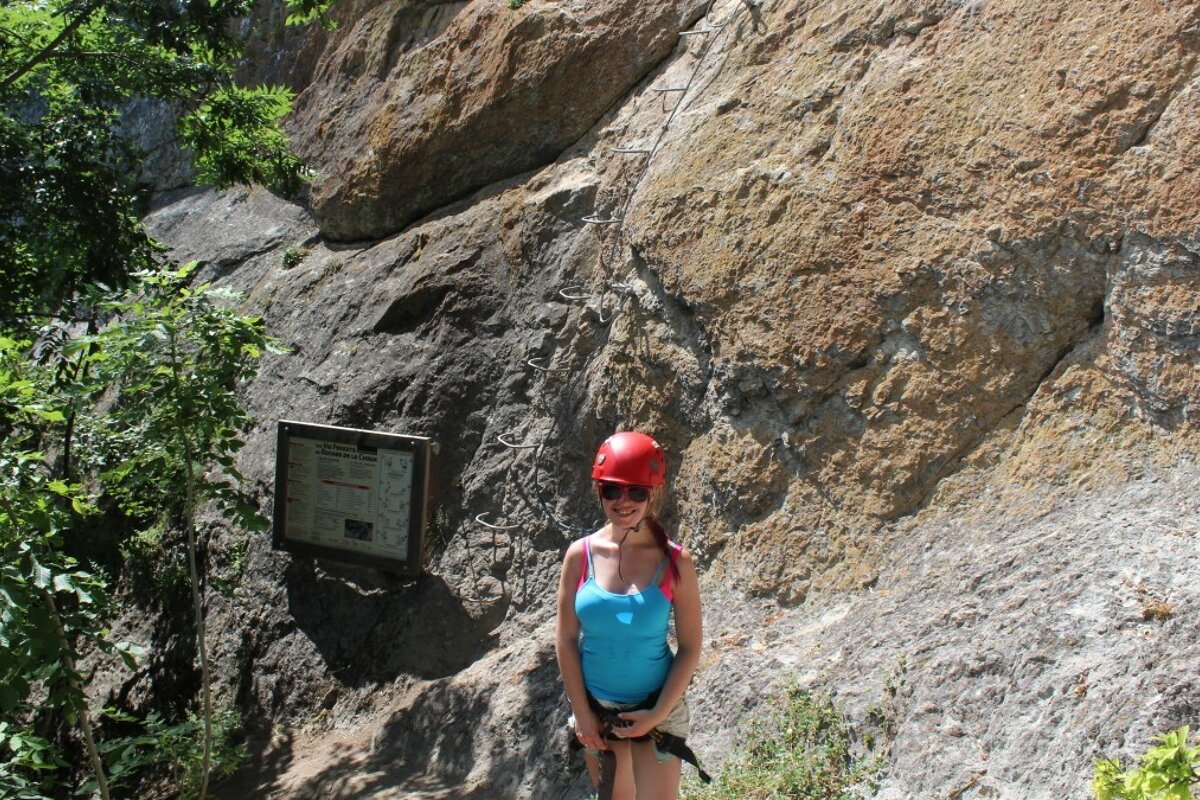 a woman in a vest top and climbing helmet