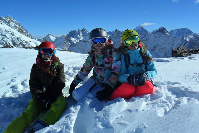 three children sat in the snow