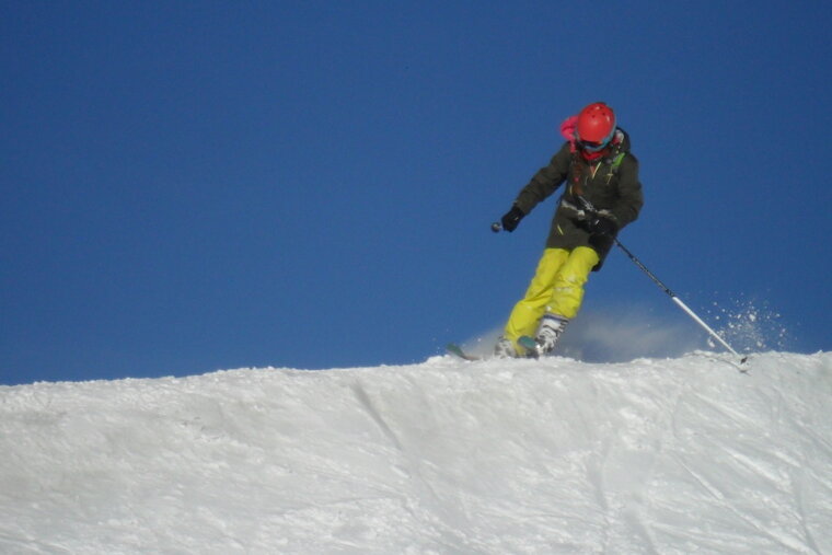 a skier in yellow pants