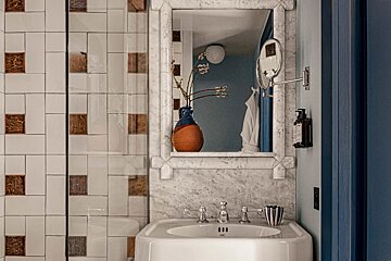 A bathroom with a sink a mirror and a vase