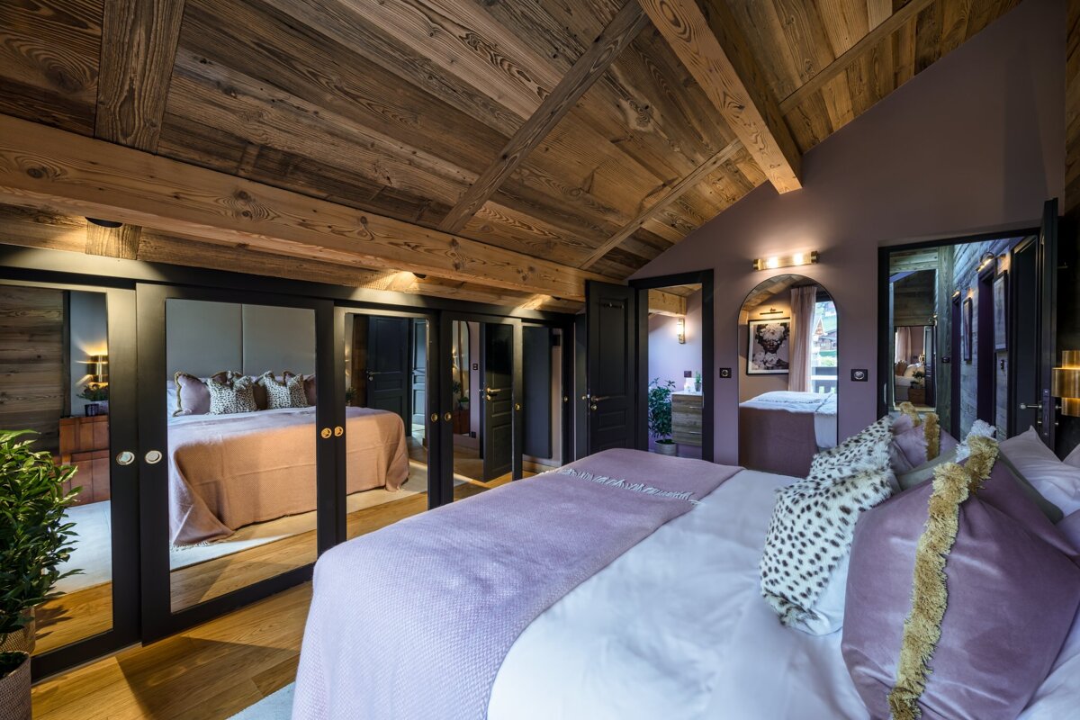A bedroom with a purple blanket and leopard print pillows