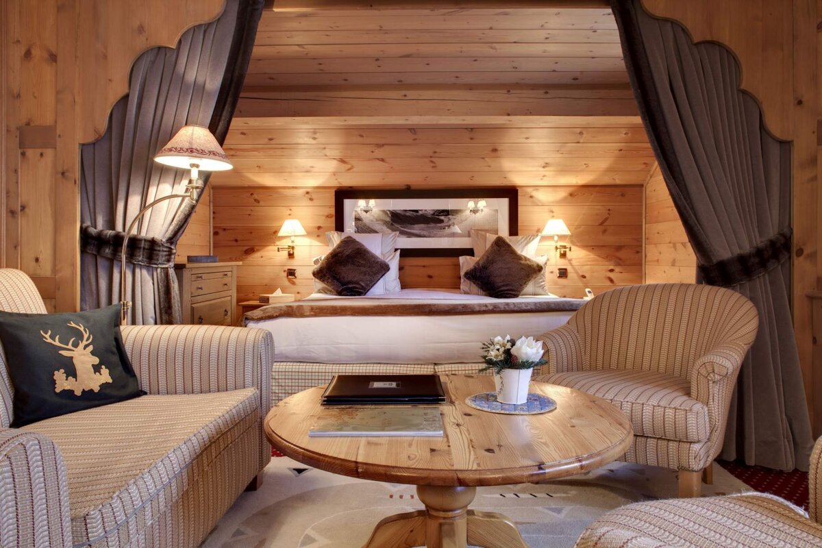 A hotel room with a bed and chairs and a table