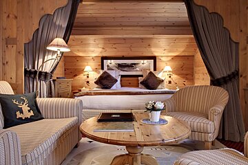 A hotel room with a bed and chairs and a table