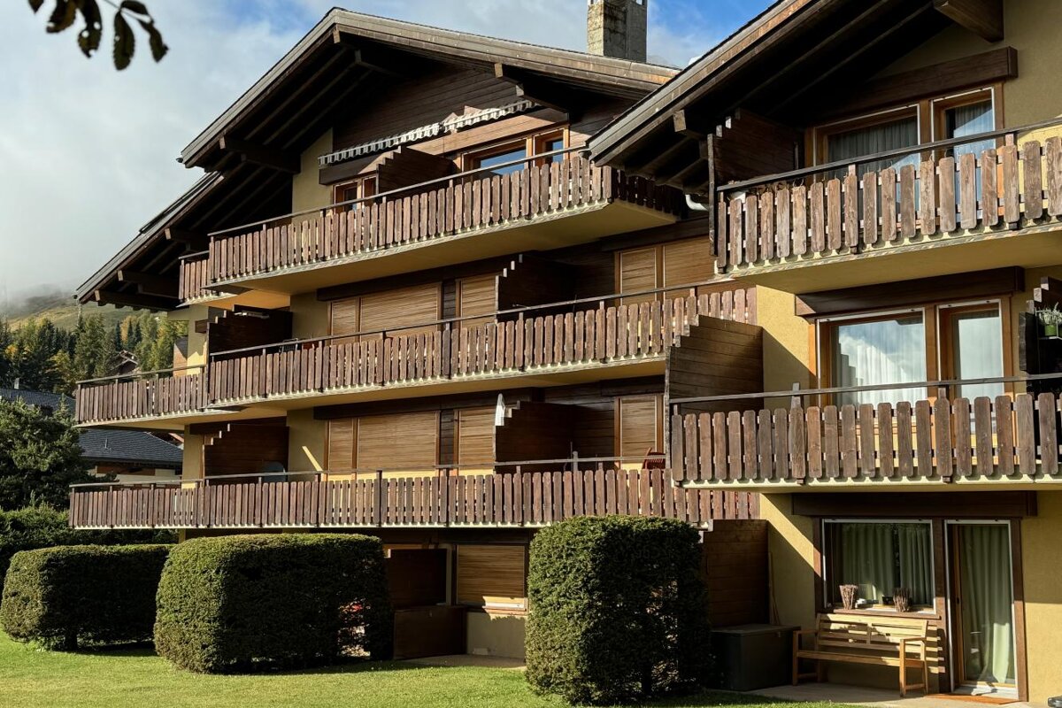 A building with a lot of balconies and a bench in front of it