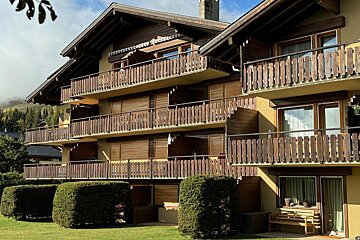 A building with a lot of balconies and a bench in front of it