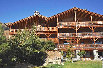 A large wooden building with a blue sky in the background