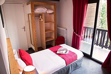 A bedroom with a single bed and a sliding glass door