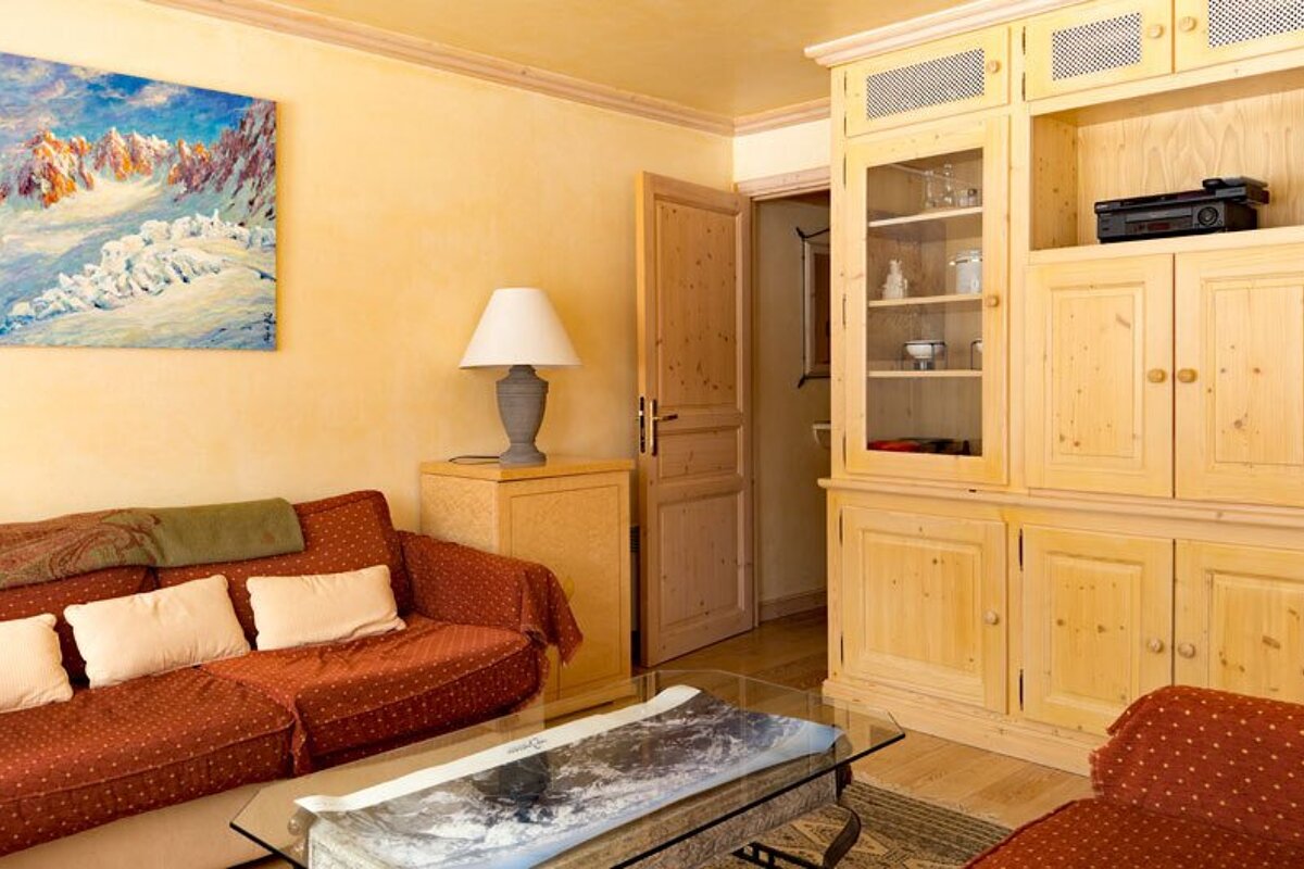 A living room with a painting on the wall above the couch