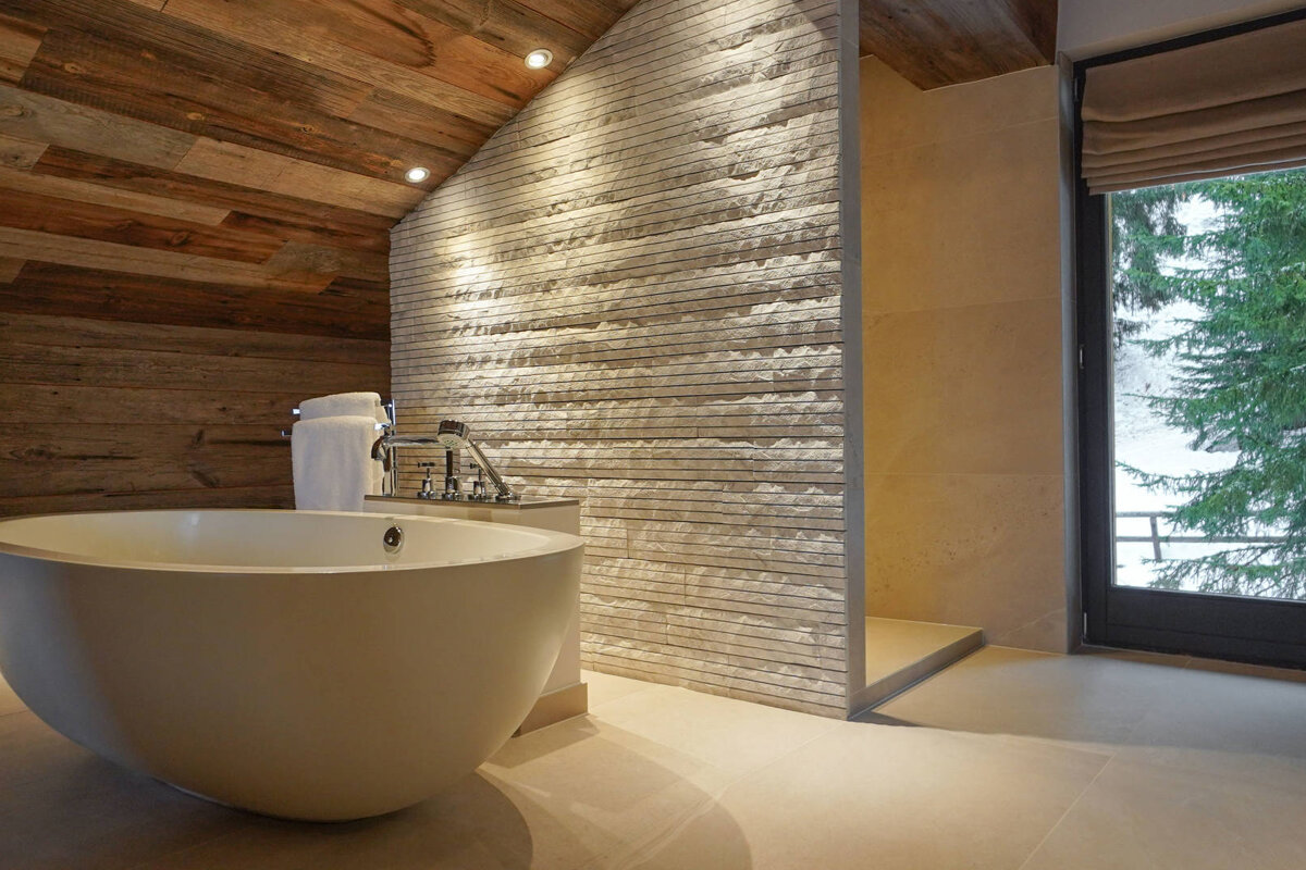 A bathtub in a bathroom with a wooden ceiling