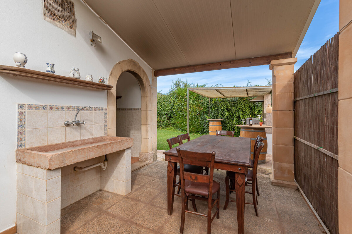 A patio with a table and chairs and a sink