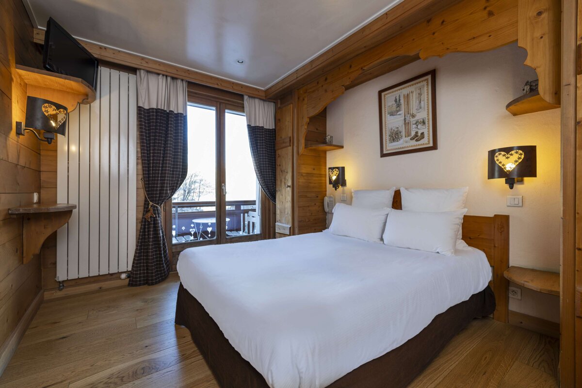 A hotel room with a bed and a picture on the wall