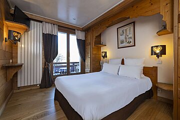 A hotel room with a bed and a picture on the wall