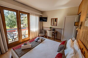 A hotel room with a large bed and a flat screen tv