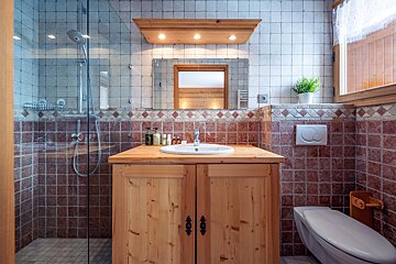 A bathroom with wooden cabinets and a toilet