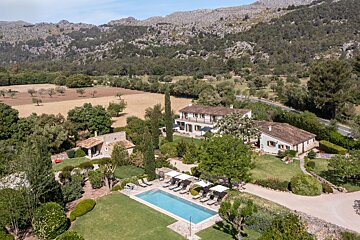 An aerial view of a house with a large swimming pool