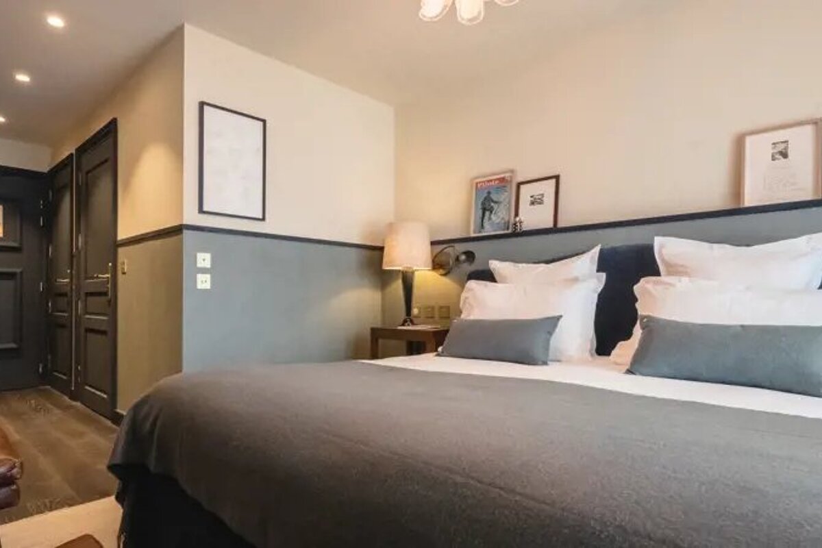 A hotel room with a king size bed and a chair