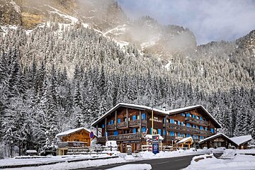 A ski resort is surrounded by snow covered trees