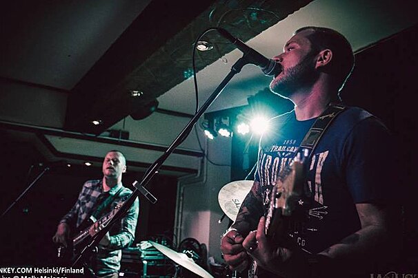 two men playing guitar & singing