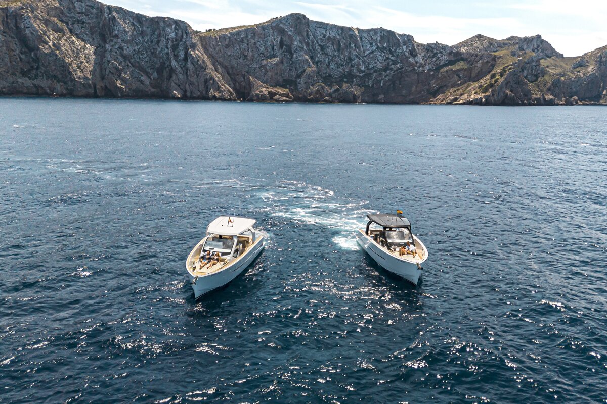 Two boats in the ocean with mountains in the background