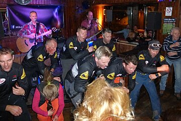 a group of men dancing in a bar