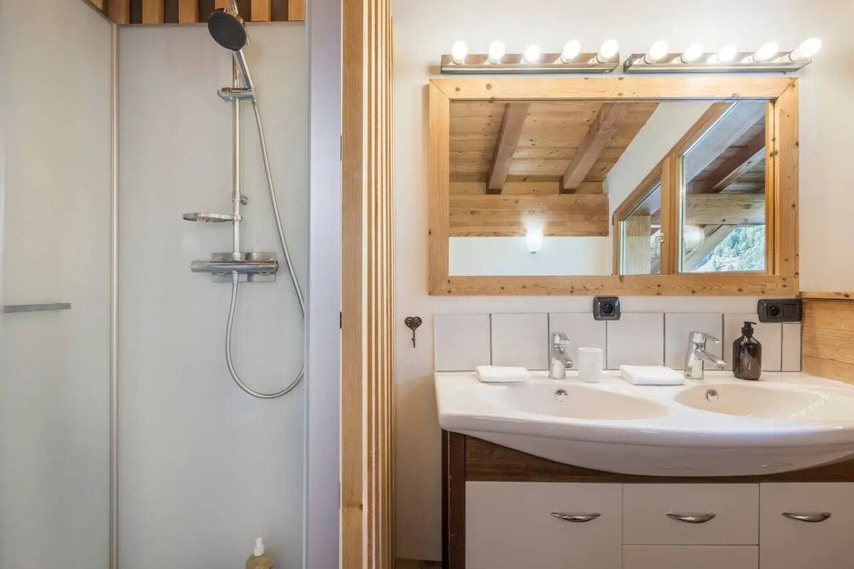 A bathroom with two sinks and a large mirror
