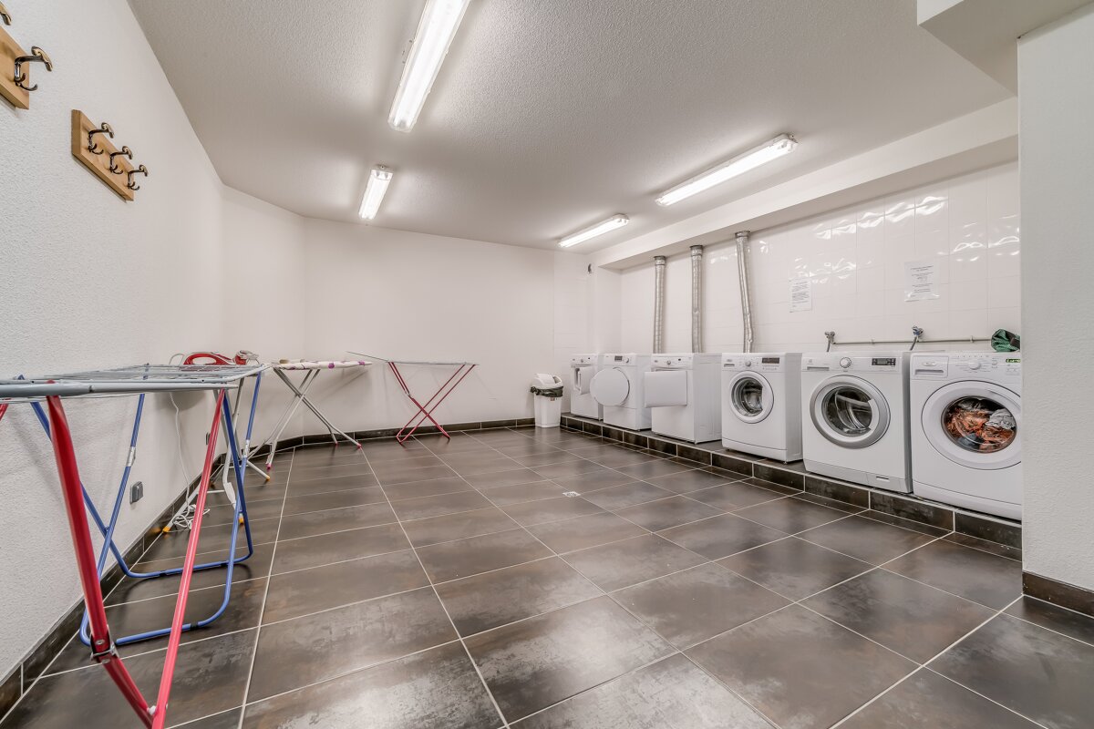 A row of washers and dryers in a laundry room