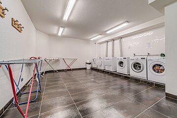 A row of washers and dryers in a laundry room