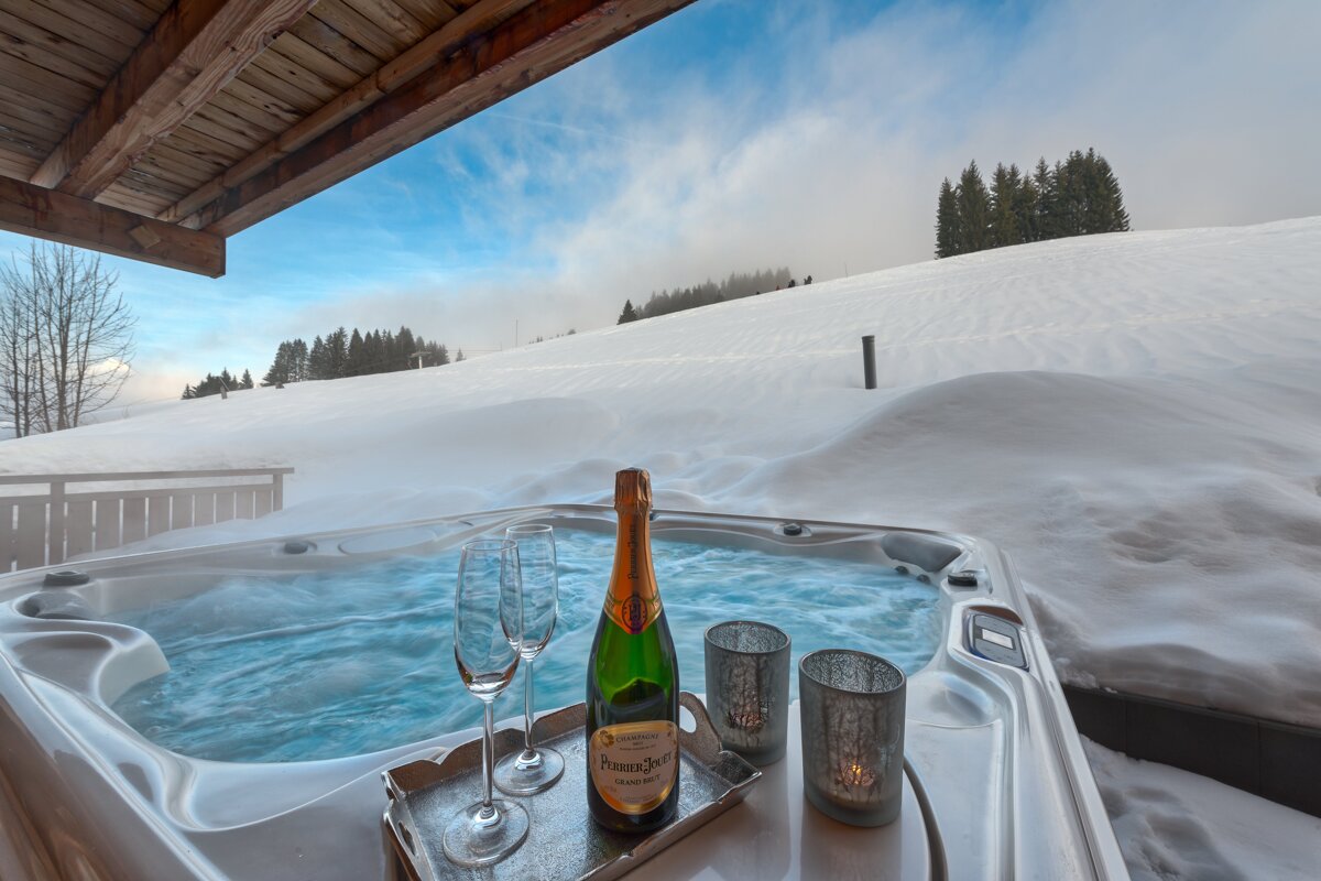 A bottle of perrier jouet champagne sits in a hot tub