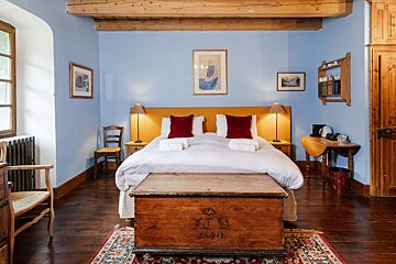 A bedroom with a bed and a trunk with the year 1840 on it
