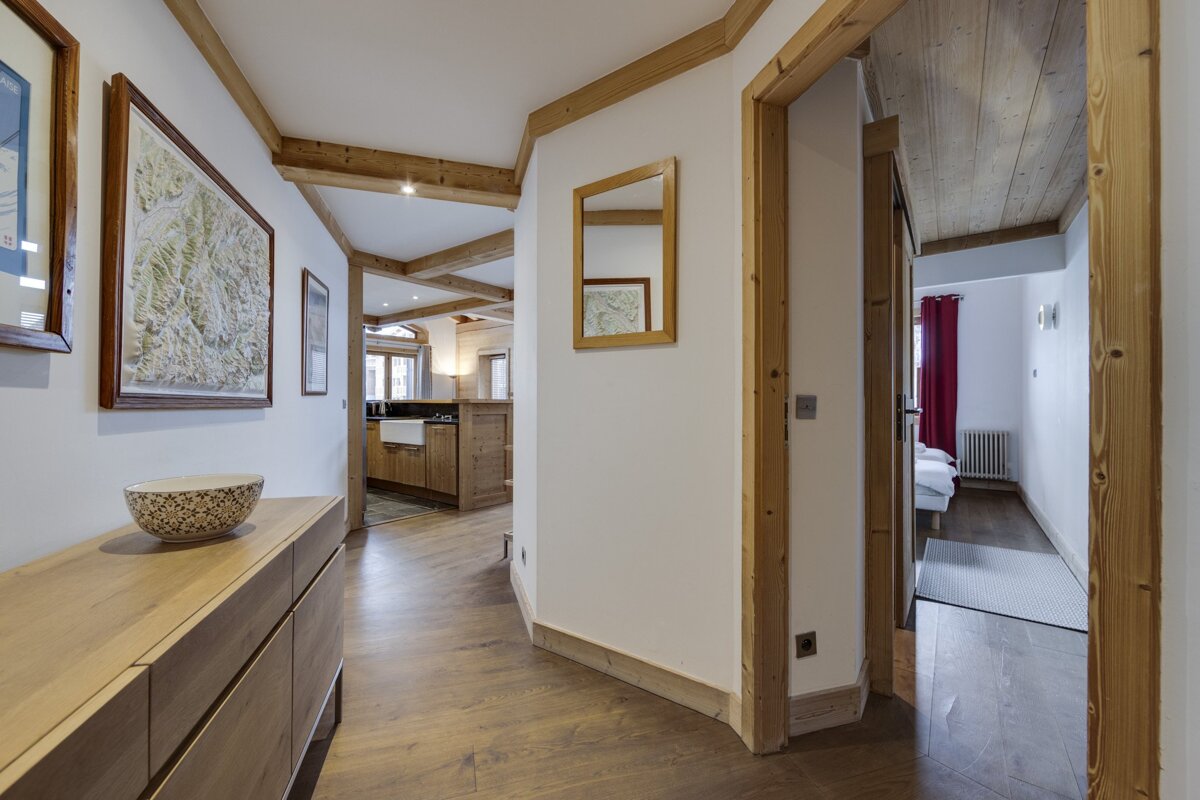 A hallway in a house with a mirror on the wall