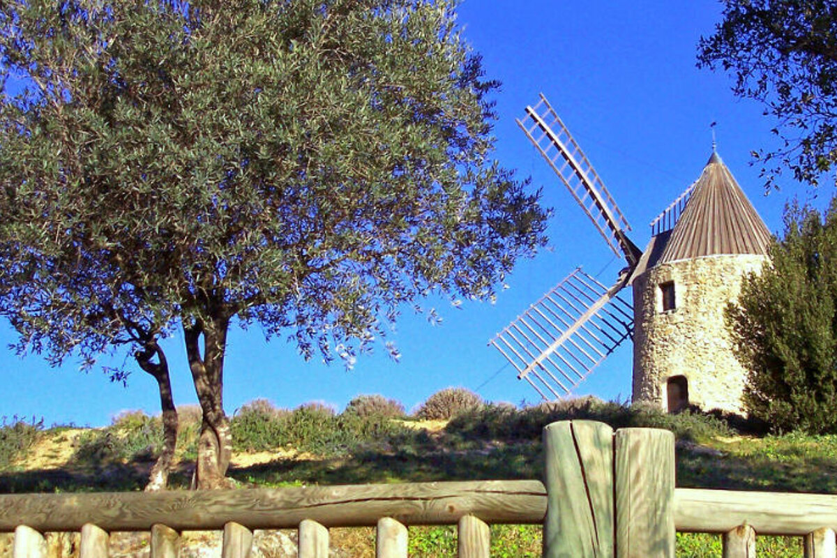 A wooden fence with a windmill in the background