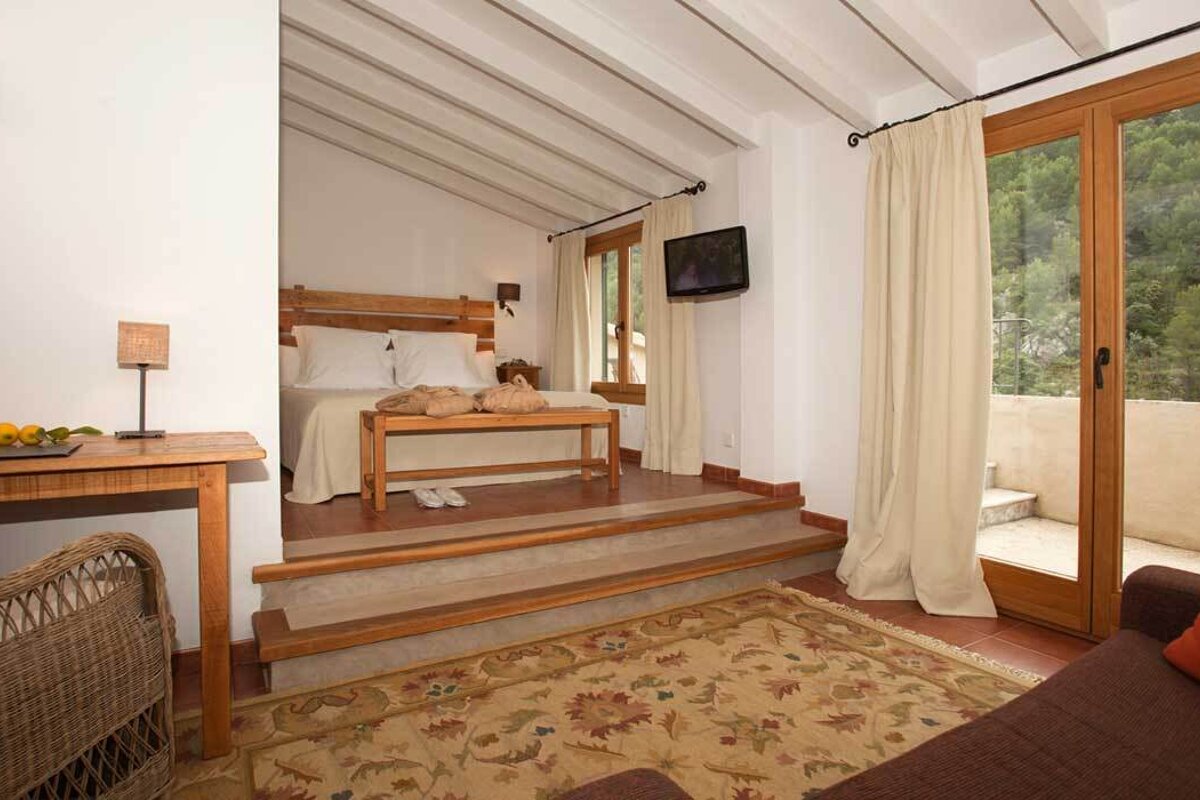 A bedroom with a bed and a television on the wall