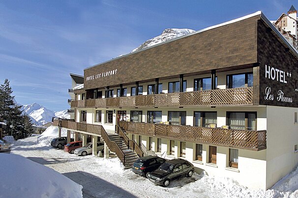 A hotel with cars parked in front of it