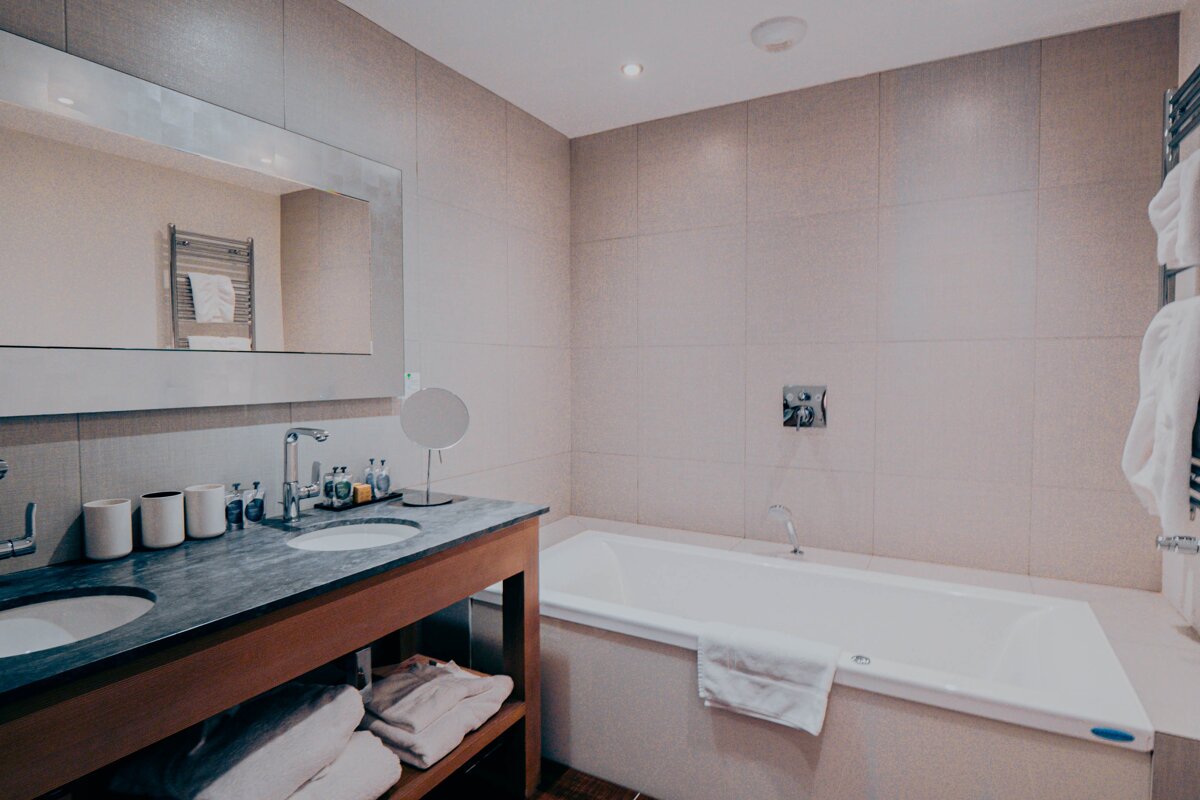 A bathroom with two sinks and a bathtub