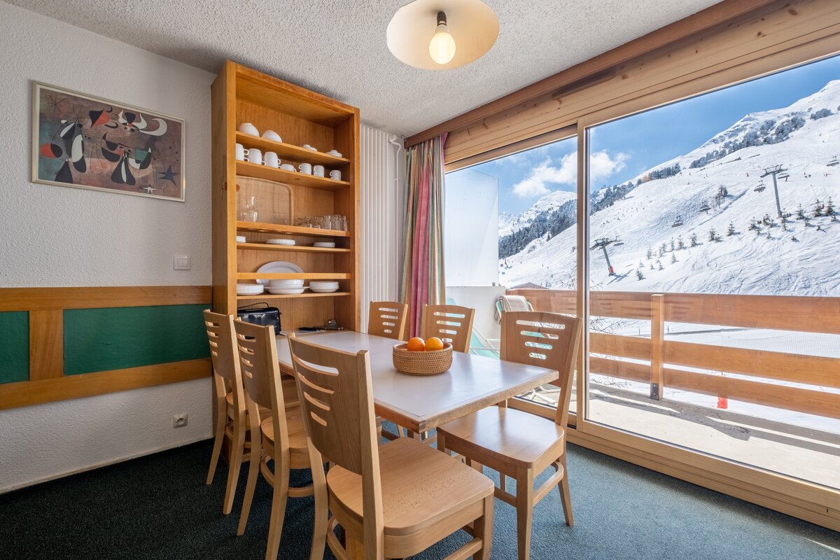 A dining room table with a bowl of oranges on it