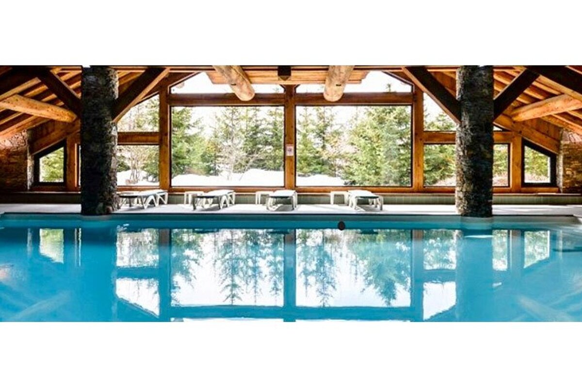 A large indoor swimming pool with a lot of windows