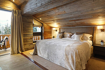 A bedroom with a large bed and a balcony