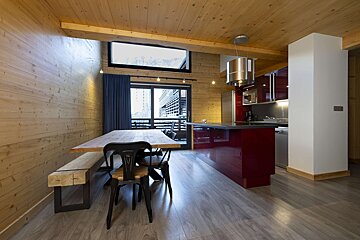 A kitchen with red cabinets and a wooden table