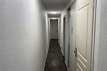 A hallway with a sign on the wall that says ' emergency exit '