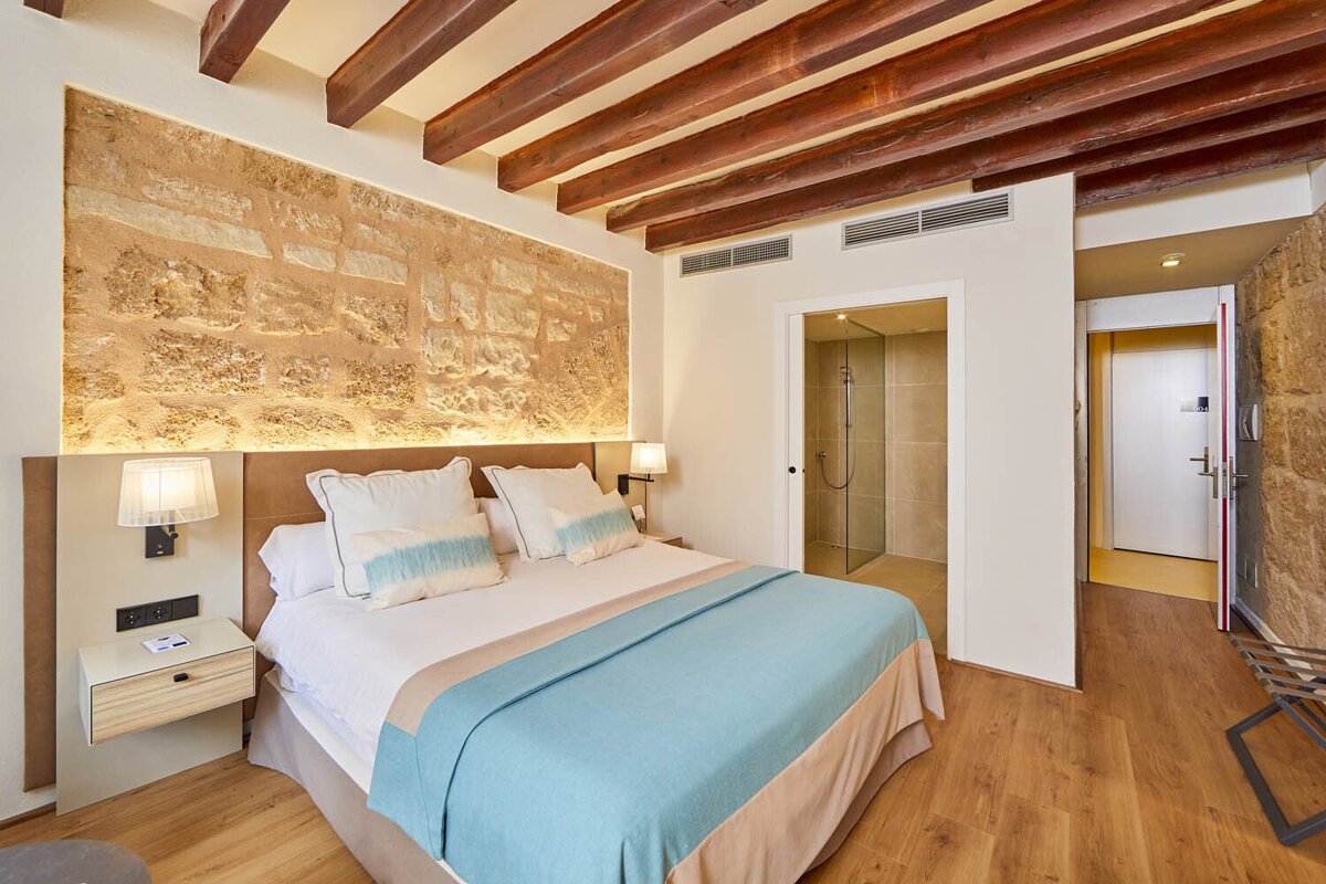 A hotel room with a large bed and wooden beams