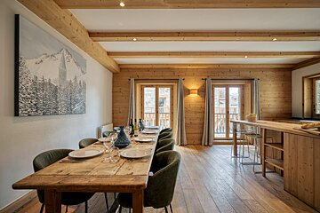 A dining room with a long wooden table and chairs