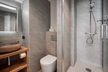 A bathroom with a toilet a sink and a shower