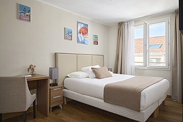 A bedroom with a single bed and a cannes poster on the wall